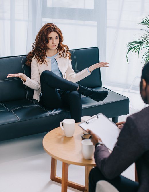 Mujer sentada en un sofá explicando su situación a un psicólogo